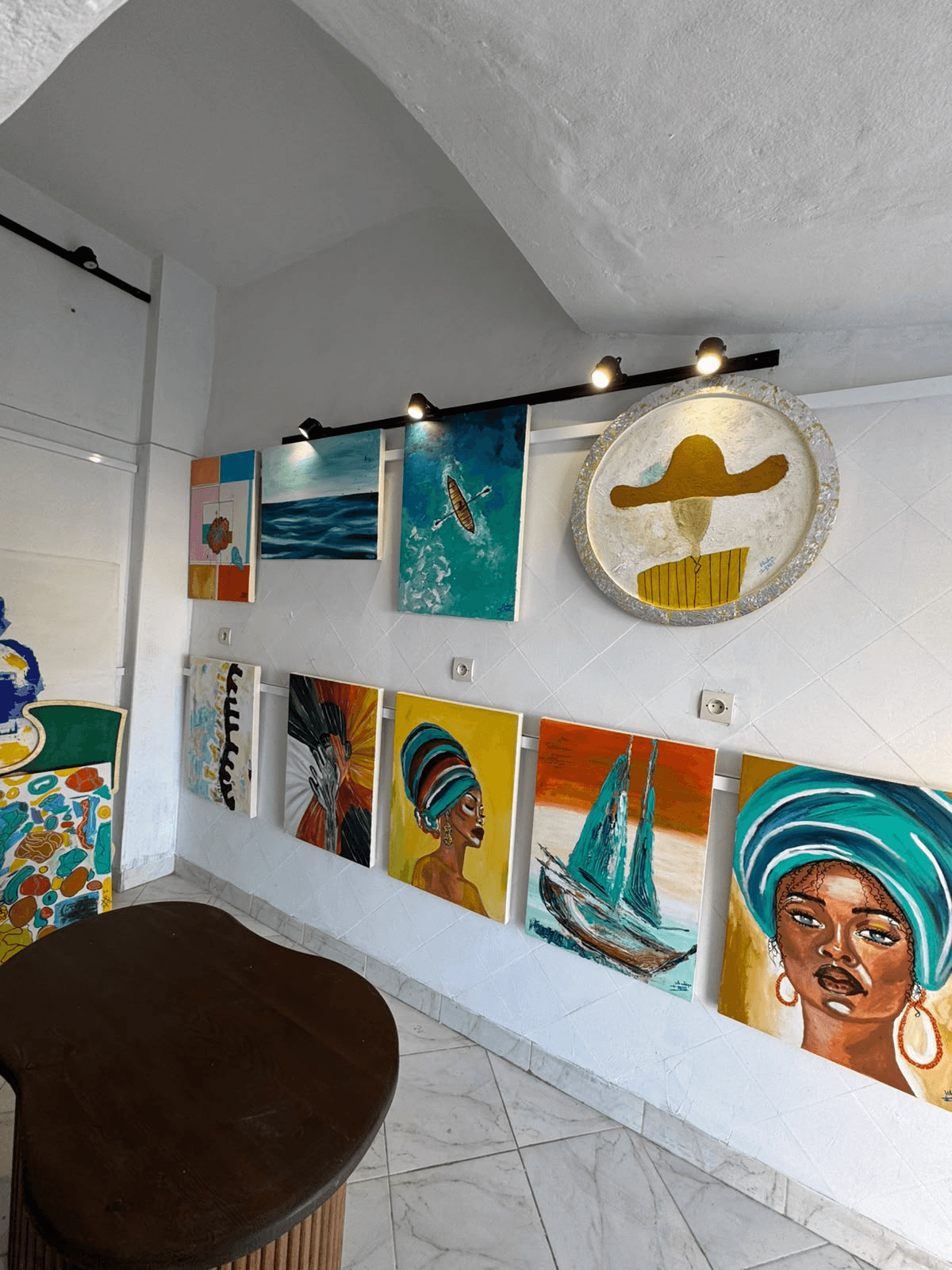 Paintings displayed along the wall of Maison Art Deco's Essaouira studio